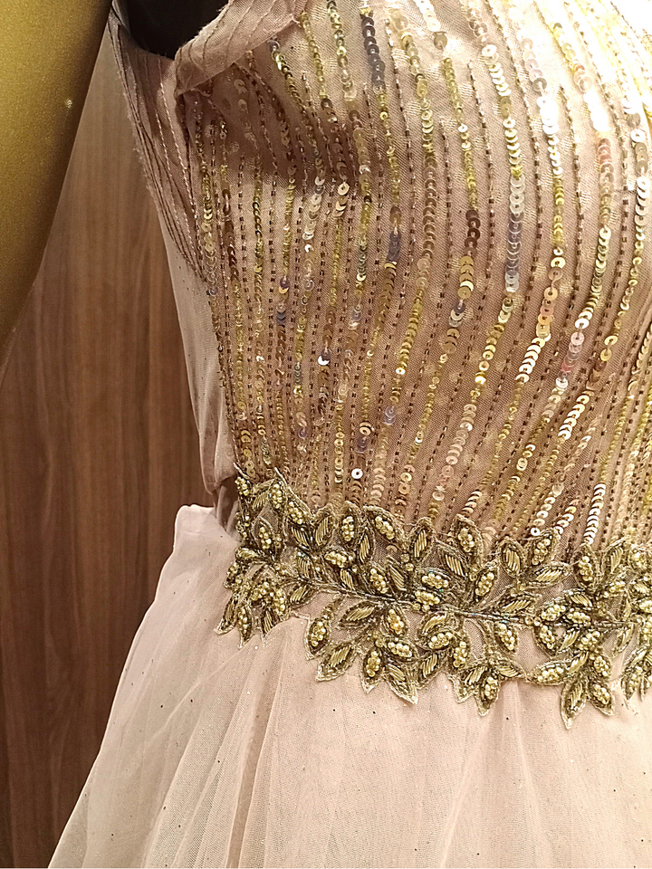 Rose Gold Flared Net Gown With Ruffled Layering & Floral Sequence Embroidery