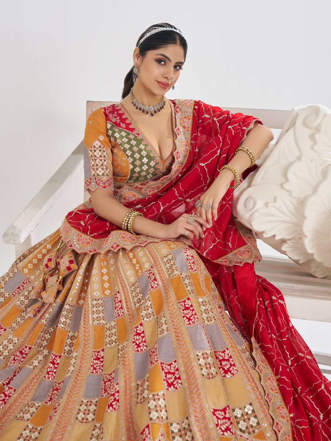 Multi-colour patchwork lehenga choli with mirror, zari & gota embroidery and bandhani dupatta.