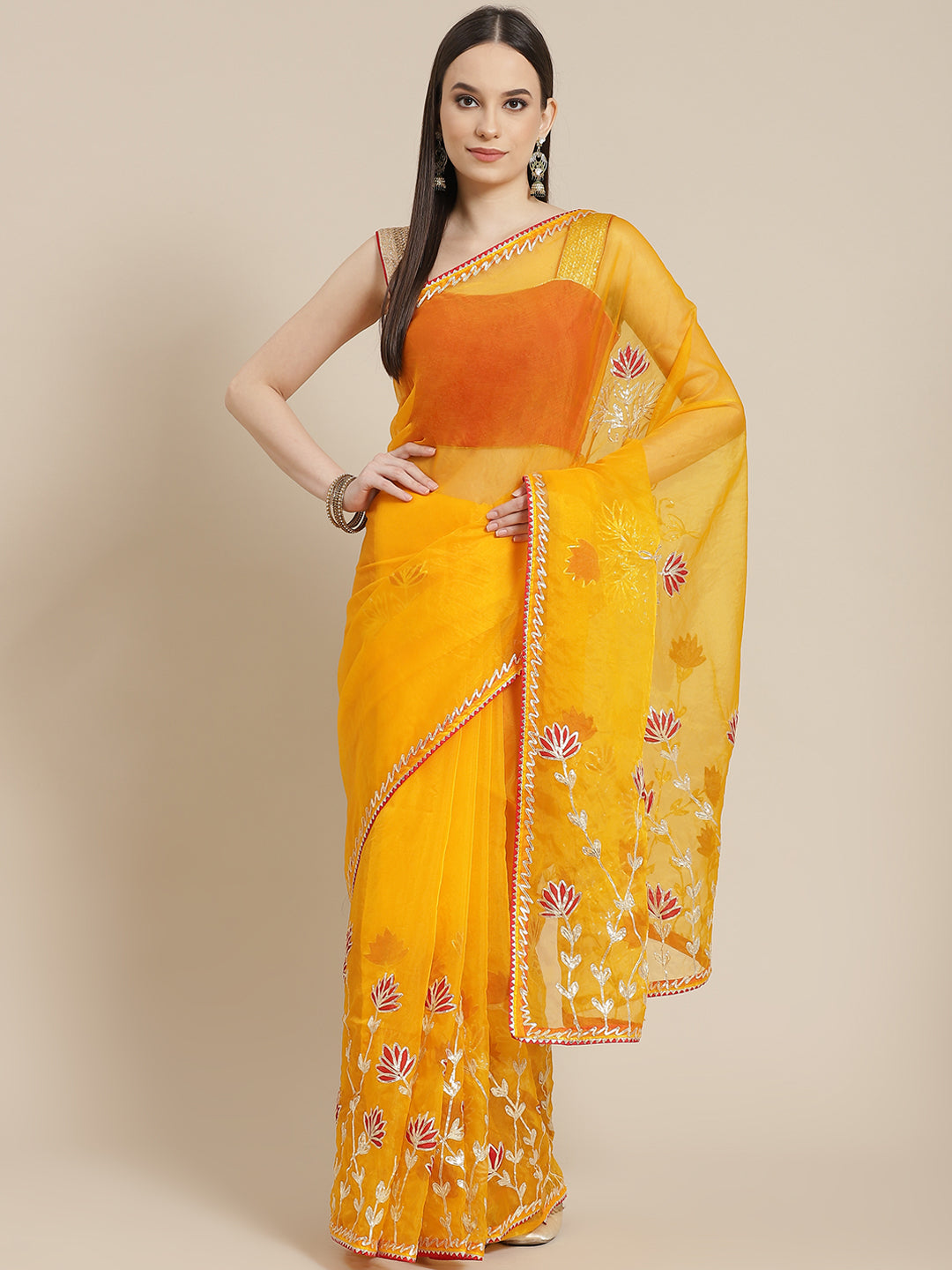 Chhabra 555 Mustard Organza Jaipuri Saree with Gota Patti & Resham Embroidery and Contrast Blouse

Color: Mustard

Type: NA Sarees

Pattern: Embellished

Pattern Type: Floral

Ornamentation: Gotta Patti

Border: Embroidered

Fabric: Organza

Saree length: 5.40 mtr., Width: 1.10 mtr, Blouse length: 0.70 mtr
Dry Clean only

The CAD image gives a detailed look of the actual blouse piece that comes with this saree. The blouse used by the model in the pictures is only for styling purpose.