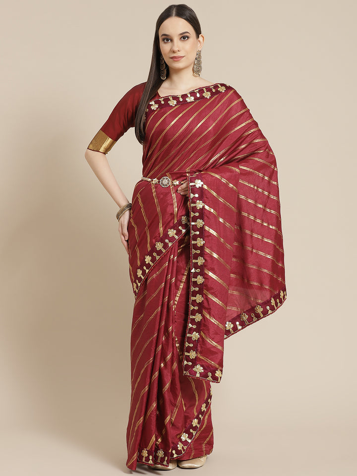 Chhabra 555 Foil print Leheriya Style Saree with Gota Patti Embroidery Border & Matching Belt

Color: Burgundy

Type: Leheriya Sarees

Pattern: Embellished

Pattern Type: Leheriya

Ornamentation: Gotta Patti

Border: Embroidered

Fabric: Silk Blend

Saree length: 5.00 mtr., Width: 1.10 mtr, Blouse length: 0.70 mtr
Dry Clean only

The CAD image gives a detailed look of the actual blouse piece that comes with this saree. The blouse used by the model in the pictures is only for styling purpose.